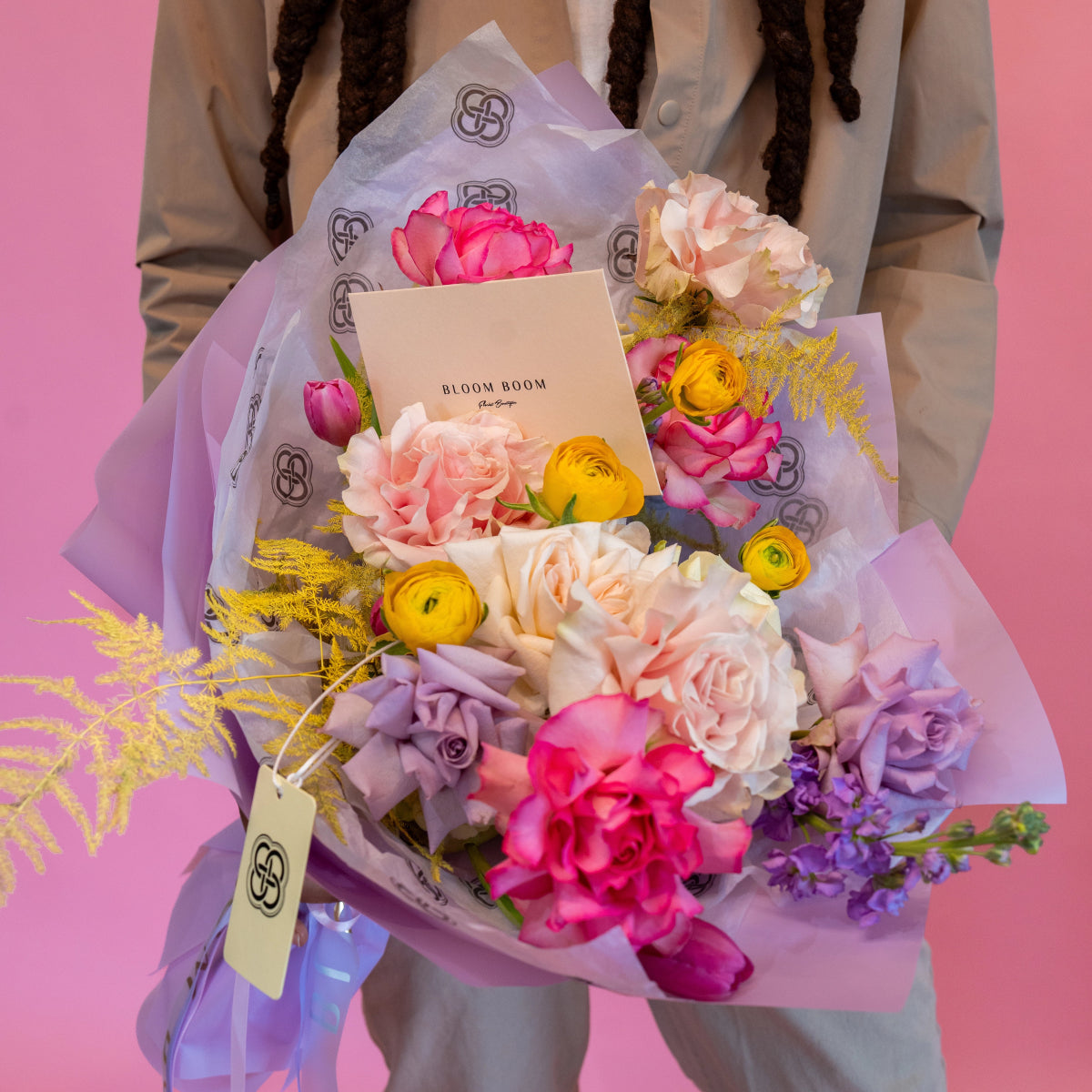 Bloom Boom mixed flower bouquet with pink peonies, yellow ranunculus, purple roses in lavender wrapping paper