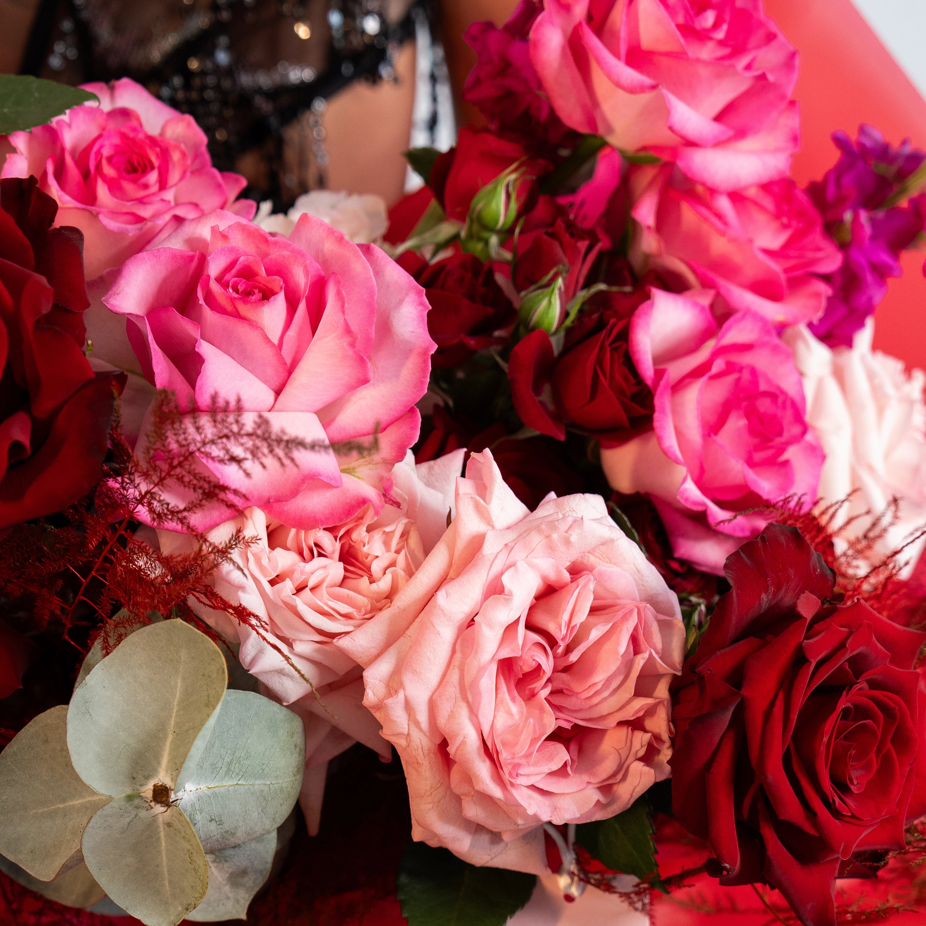 Mixed rose bouquet with pink, coral, and burgundy roses accented with eucalyptus leaves for Los Angeles delivery