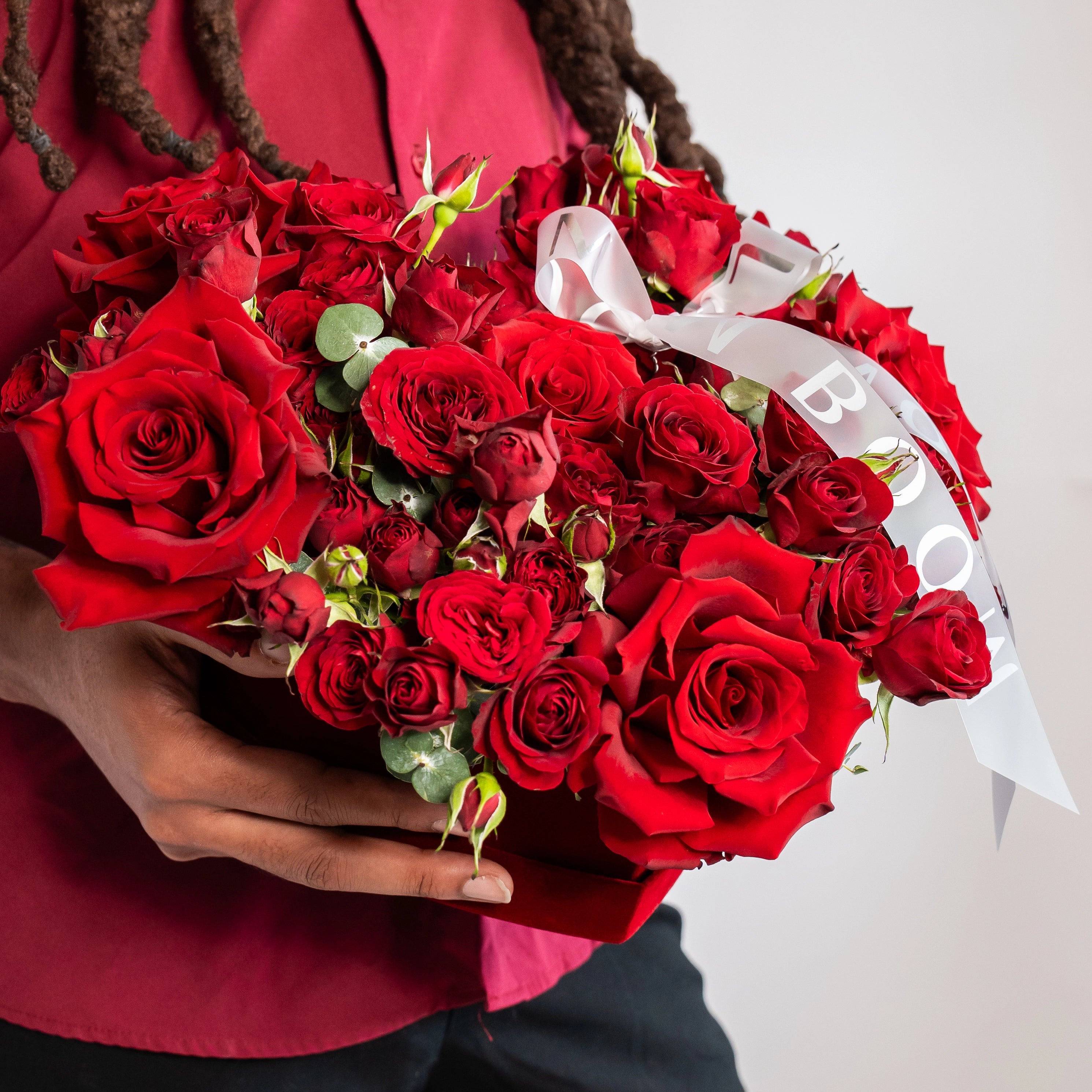 Elegant red rose bouquet with eucalyptus greenery and white ribbon, perfect for romantic occasions
