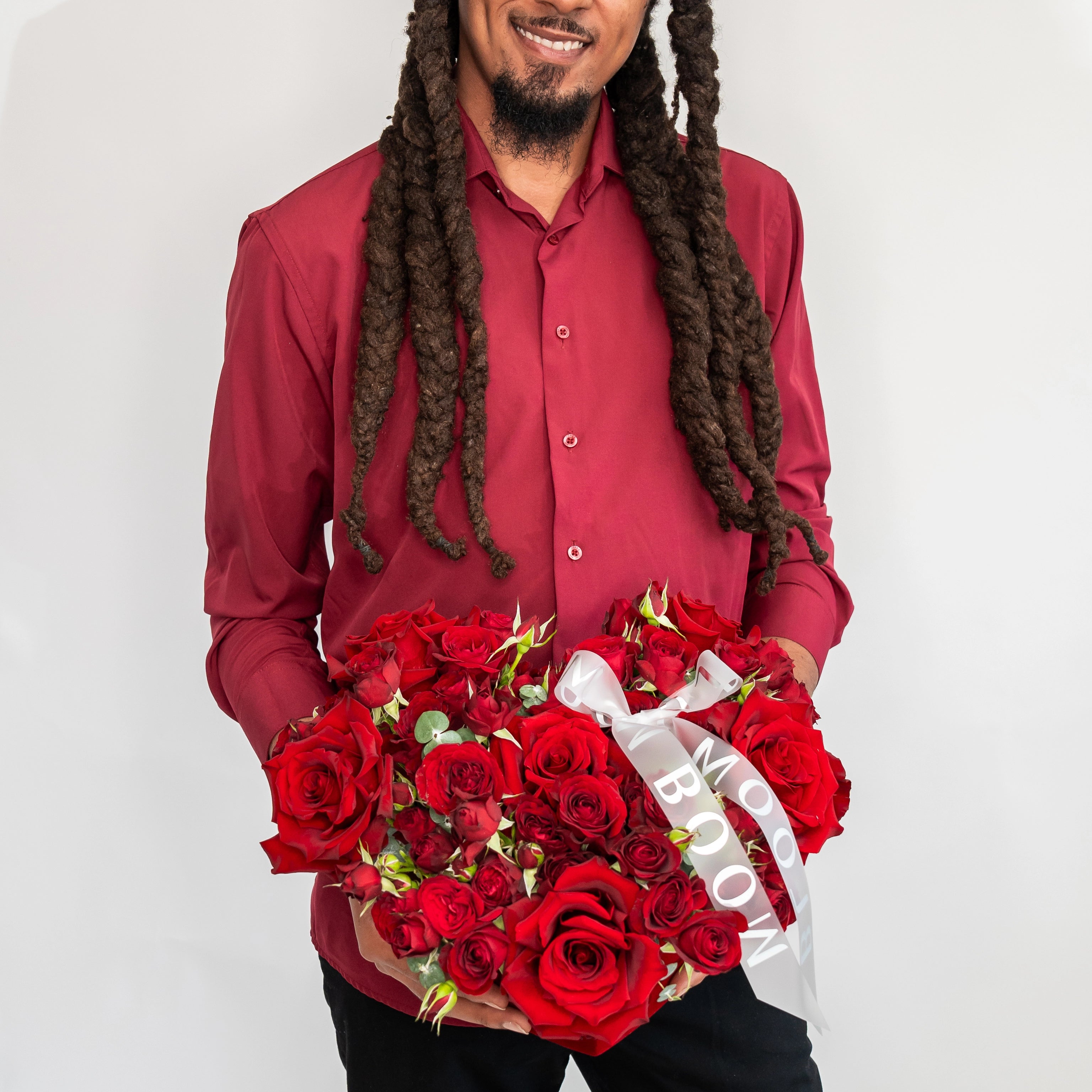 Red rose heart-shaped flower box with white ribbon held by delivery person for Valentine's Day Los Angeles