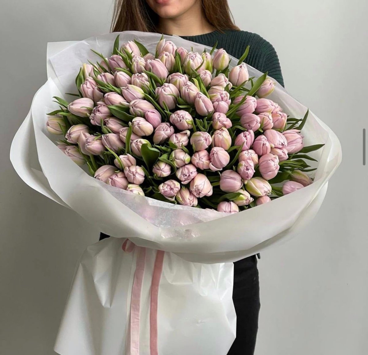 Large bouquet of 75 soft pink tulips wrapped in white paper with pink ribbon ties
