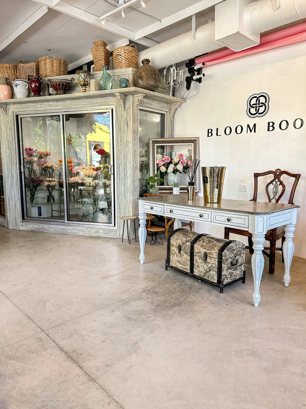 Bloom Boom branded wall signage above a console table beside the walk-in flower cooler
