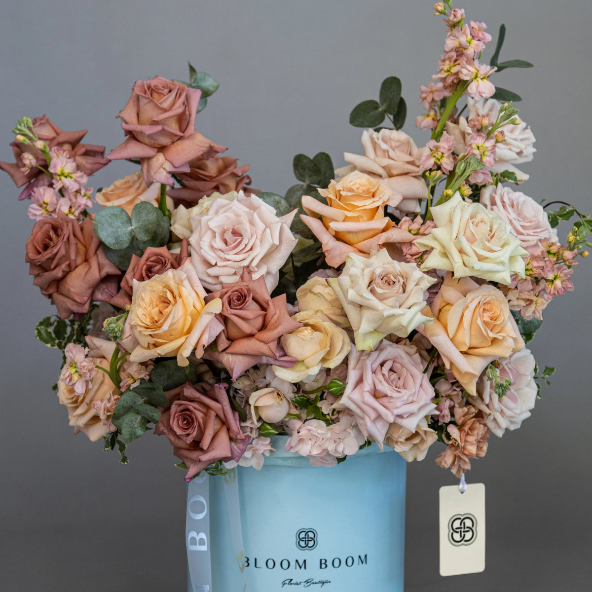 Luxury mixed rose bouquet in dusty rose, peach and cream tones with eucalyptus in blue Bloom Boom flower box