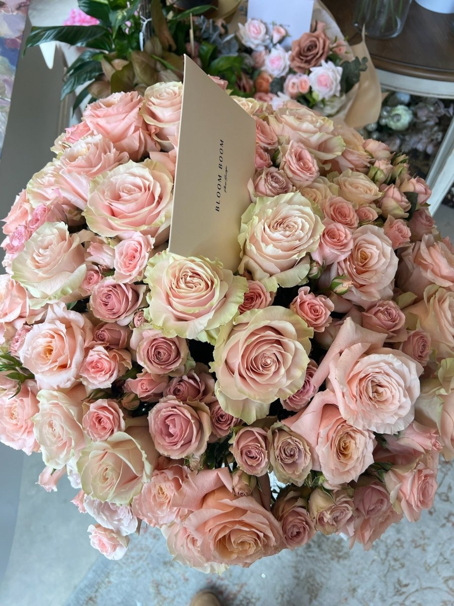 Large bouquet of 50 blush pink and cream roses with kraft paper wrapping and branded tag