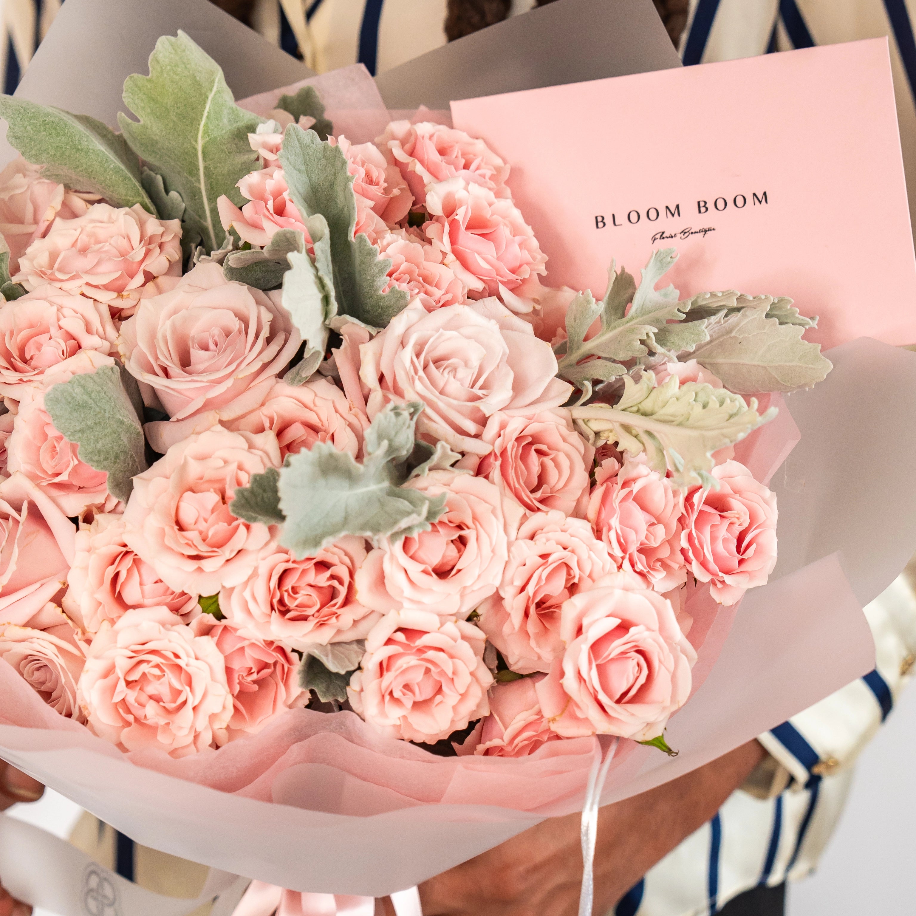 Blush pink rose bouquet with dusty miller foliage wrapped in pink paper from Bloom Boom Flowers Los Angeles