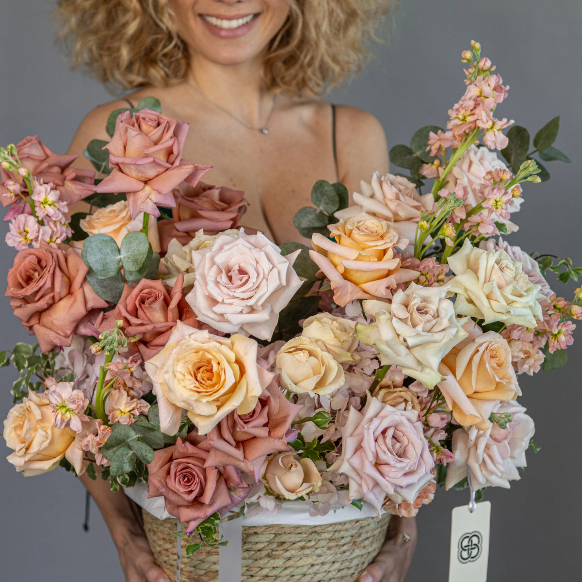 Luxury flower basket with blush pink roses, cream roses, eucalyptus and stock flowers in woven natural basket